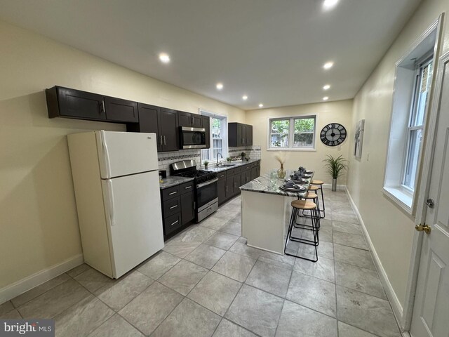 2411 N W St, Wilmington, DE 19802 - kitchen with stainless steel appliances, a center island, recessed lighting, dark cabinetry, and decorative backsplash