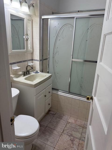 812 Emerson St NW, Washington, DC 20011 - full bath featuring vanity, tile walls, and tiled shower / bath combo