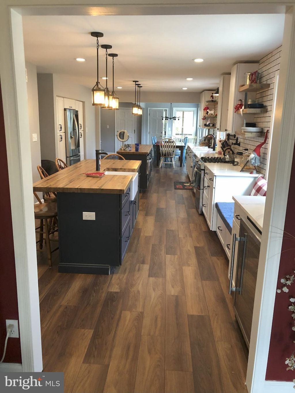 153 Drexel Dr, Severna Park, MD 21146 - kitchen featuring butcher block counters, stainless steel appliances, open shelves, a breakfast bar area, and dark wood-style floors