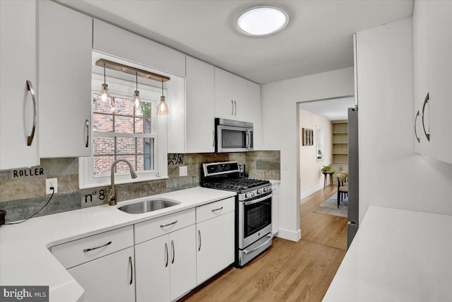 109 Wyomissing Blvd, Wyomissing, PA 19610 - kitchen with stainless steel appliances, light wood-style floors, tasteful backsplash, and white cabinetry