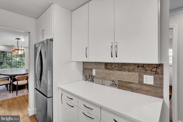 109 Wyomissing Blvd, Wyomissing, PA 19610 - kitchen featuring freestanding refrigerator, light wood-style floors, backsplash, white cabinets, and light countertops