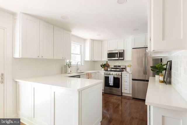 19023 Staleybridge Rd, Germantown, MD 20876 - kitchen with appliances with stainless steel finishes, a peninsula, tasteful backsplash, and white cabinetry