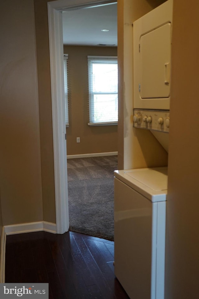 324 W 29th St, Baltimore, MD 21211 - laundry area with stacked washer / dryer, dark carpet, and dark wood-type flooring