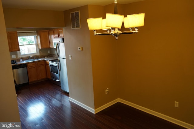 324 W 29th St, Baltimore, MD 21211 - kitchen with stainless steel appliances, dark wood finished floors, a chandelier, and decorative light fixtures