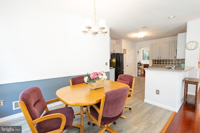 39 Mission Way, Barnegat, NJ 08005 - dining space featuring light wood-style floors, arched walkways, and a chandelier