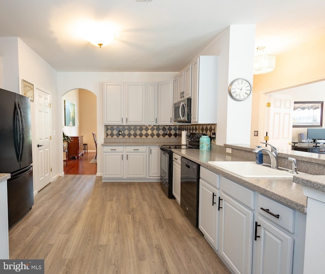 39 Mission Way, Barnegat, NJ 08005 - kitchen featuring black appliances, arched walkways, light wood-style floors, decorative backsplash, and white cabinets