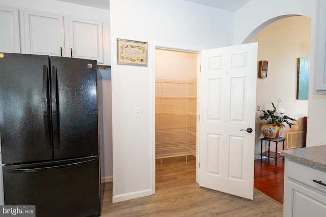 39 Mission Way, Barnegat, NJ 08005 - kitchen featuring freestanding refrigerator, arched walkways, white cabinets, and light wood-style floors