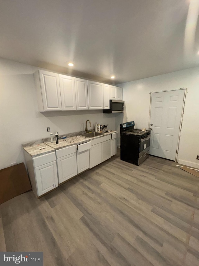 4335 N 15th St, Philadelphia, PA 19140 - kitchen featuring black range, wood finished floors, white cabinets, light countertops, and recessed lighting