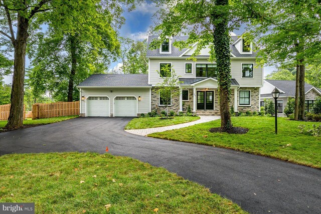 569 Riverside Dr, Princeton, NJ 08540 - view of front facade with stone siding, an attached garage, and driveway