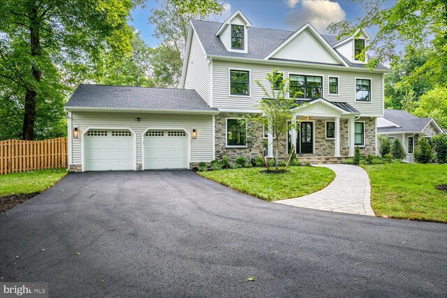 569 Riverside Dr, Princeton, NJ 08540 - view of front of property featuring a garage, stone siding, asphalt driveway, and a shingled roof