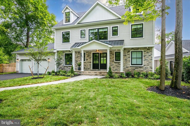 569 Riverside Dr, Princeton, NJ 08540 - view of front of home with stone siding, driveway, an attached garage, a standing seam roof, and a metal roof