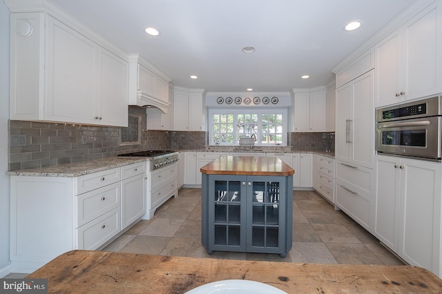 431 Waynesbrooke Rd, Berwyn, PA 19312 - kitchen with stainless steel appliances, wooden counters, white cabinets, decorative backsplash, and recessed lighting