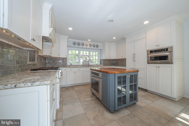 431 Waynesbrooke Rd, Berwyn, PA 19312 - kitchen with wood counters, appliances with stainless steel finishes, white cabinets, backsplash, and recessed lighting