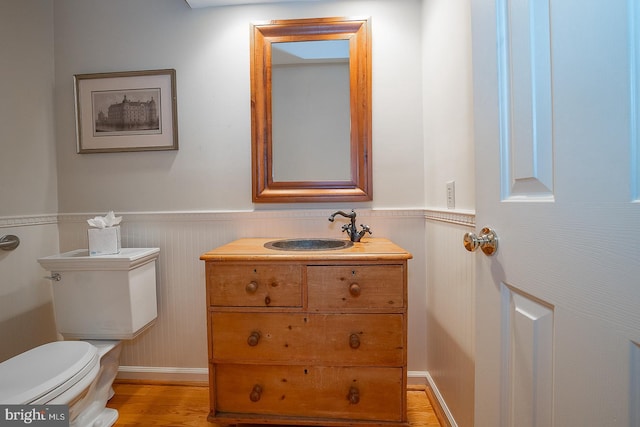 431 Waynesbrooke Rd, Berwyn, PA 19312 - half bathroom featuring a wainscoted wall, vanity, and wood finished floors