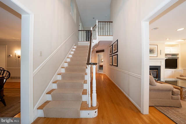 431 Waynesbrooke Rd, Berwyn, PA 19312 - stairs featuring a glass covered fireplace, wood finished floors, and recessed lighting