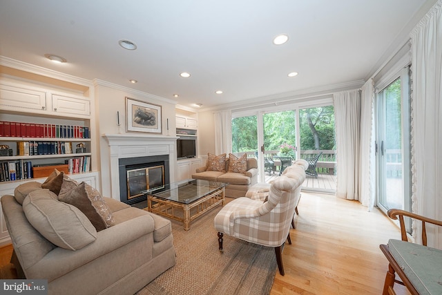 431 Waynesbrooke Rd, Berwyn, PA 19312 - living area featuring ornamental molding, light wood-style flooring, a glass covered fireplace, recessed lighting, and built in features