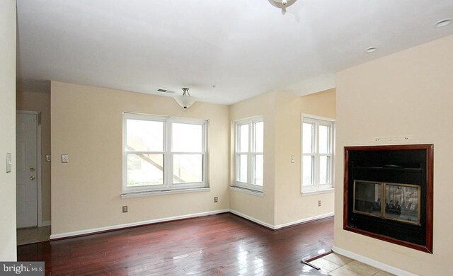 13406 Shady Knoll Dr Unit 105/G1, Silver Spring, MD 20904 - unfurnished living room featuring a multi sided fireplace and hardwood / wood-style flooring