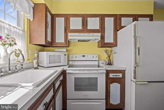 59 Saint Davids Pl, Southampton, NJ 08088 - kitchen with white appliances, extractor fan, light countertops, and glass insert cabinets