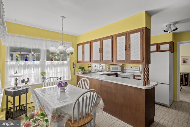 59 Saint Davids Pl, Southampton, NJ 08088 - kitchen with white appliances, glass insert cabinets, light countertops, a chandelier, and a peninsula