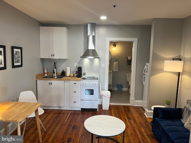23 E Beverley St, Staunton, VA 24401 - kitchen featuring white range oven, wall chimney range hood, dark wood finished floors, white cabinets, and recessed lighting