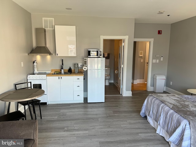 23 E Beverley St, Staunton, VA 24401 - bedroom featuring freestanding refrigerator and wood finished floors