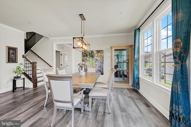 6071 Fallfish Ct, New Market, MD 21774 - dining area featuring wood finished floors, stairway, crown molding, and a chandelier