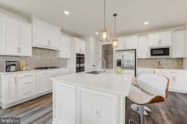 6071 Fallfish Ct, New Market, MD 21774 - kitchen with appliances with stainless steel finishes, tasteful backsplash, wood finished floors, a kitchen breakfast bar, and recessed lighting