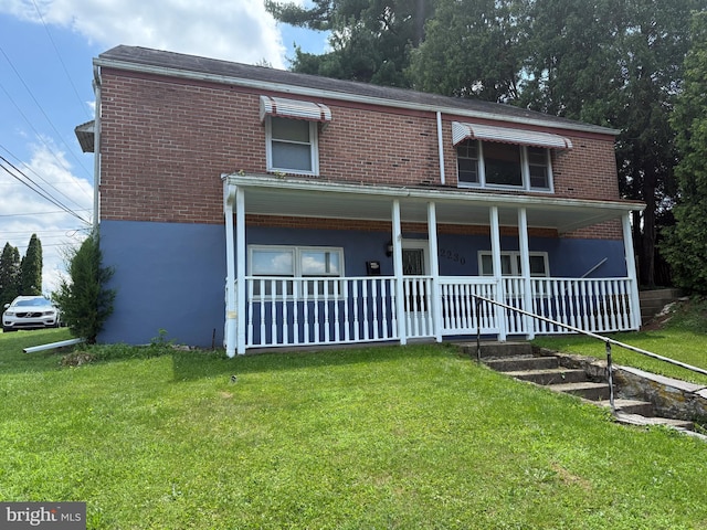 2230 Mckinley Ave, Reading, PA 19609 - view of front of house with brick siding, a front yard, and covered porch