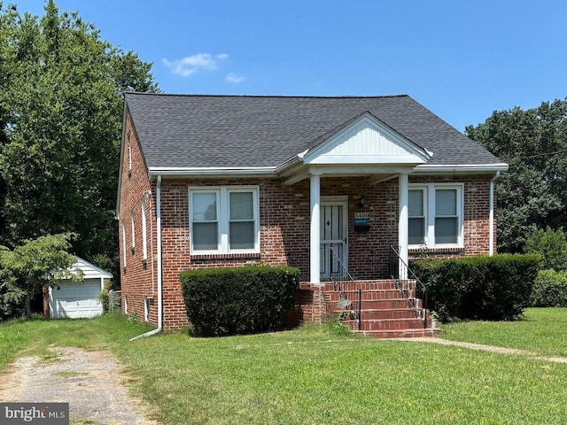 5400 54th Ave, Riverdale, MD 20737 - bungalow with brick siding, a front lawn, an outdoor structure, and a shingled roof