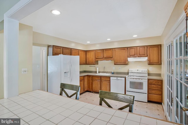 3077 Eutaw Forest Dr, Waldorf, MD 20603 - kitchen with white appliances, under cabinet range hood, brown cabinetry, recessed lighting, and light countertops
