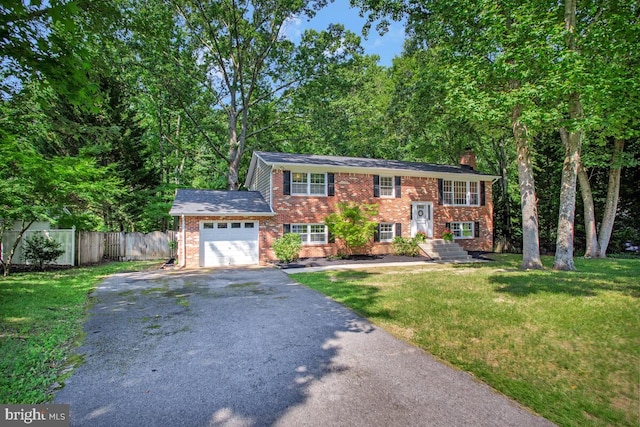 3077 Eutaw Forest Dr, Waldorf, MD 20603 - split foyer home with a chimney, a garage, asphalt driveway, and brick siding