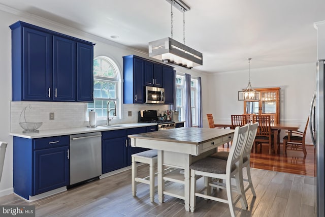 3960 Mountain View Ave, Easton, PA 18045 - kitchen with stainless steel appliances, blue cabinets, tasteful backsplash, light countertops, and ornamental molding