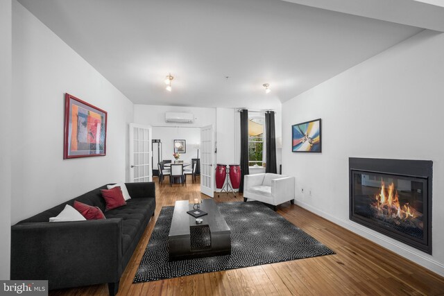 210 S High St, Baltimore, MD 21202 - living room with wood-type flooring, a glass covered fireplace, and a wall mounted AC