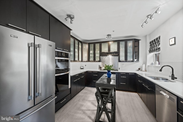 210 S High St, Baltimore, MD 21202 - kitchen with appliances with stainless steel finishes, dark cabinets, backsplash, and glass insert cabinets
