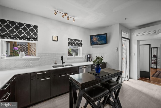 210 S High St, Baltimore, MD 21202 - kitchen featuring a wall unit AC, decorative backsplash, light countertops, and light wood finished floors