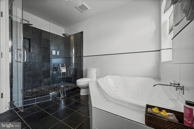 210 S High St, Baltimore, MD 21202 - full bathroom featuring a tub with jets, a stall shower, tile walls, and tile patterned floors