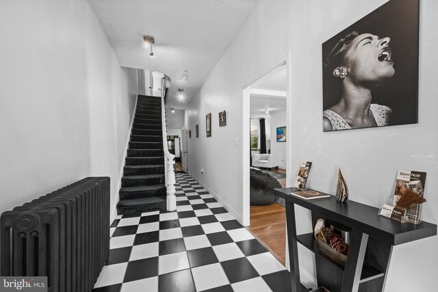 210 S High St, Baltimore, MD 21202 - corridor featuring radiator heating unit, tile patterned floors, and stairway