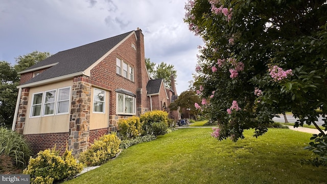4309 Walther Ave, Baltimore, MD 21214 - view of side of home with stone siding, a chimney, a yard, and roof with shingles