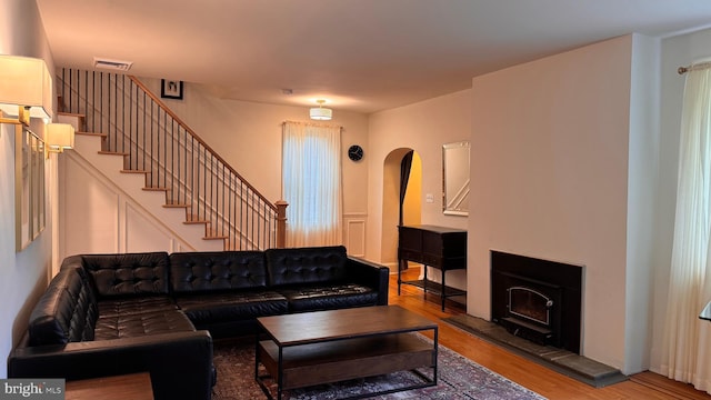 4309 Walther Ave, Baltimore, MD 21214 - living room featuring wood finished floors, stairs, arched walkways, and a tile fireplace