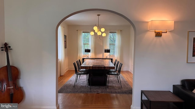 4309 Walther Ave, Baltimore, MD 21214 - dining room featuring arched walkways, light wood-style flooring, and a chandelier