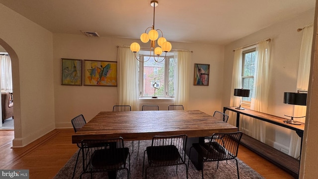 4309 Walther Ave, Baltimore, MD 21214 - dining room featuring arched walkways, wood finished floors, and a chandelier