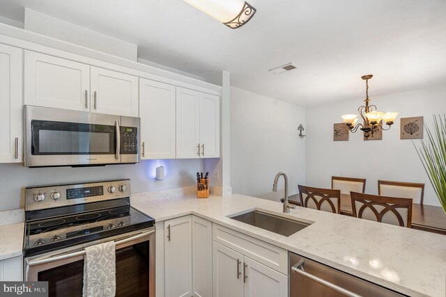 7823 Harrowgate Cir Unit D, Springfield, VA 22152 - kitchen with appliances with stainless steel finishes, a chandelier, white cabinets, light stone countertops, and pendant lighting