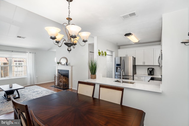 7823 Harrowgate Cir Unit D, Springfield, VA 22152 - dining area featuring a chandelier, dark wood-type flooring, and a fireplace with flush hearth