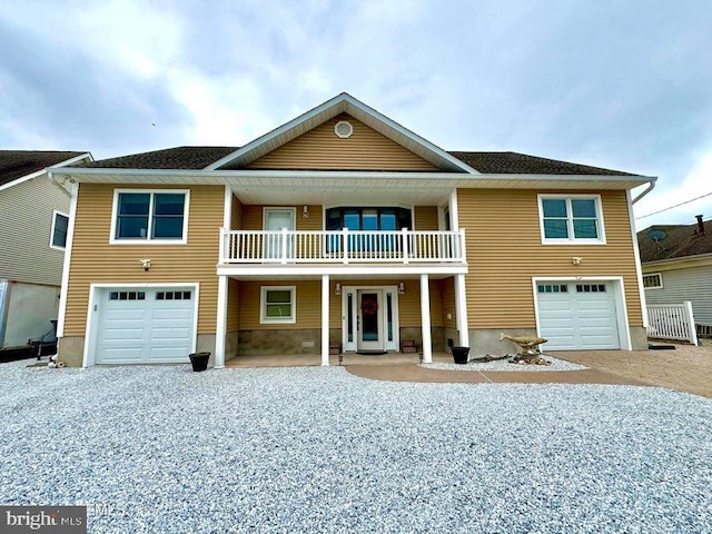 953 Capstan Dr, Forked River, NJ 08731 - view of front facade featuring an attached garage, a balcony, and gravel driveway
