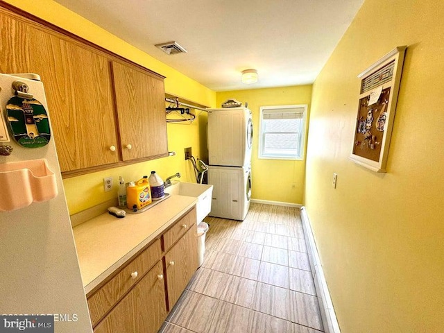 953 Capstan Dr, Forked River, NJ 08731 - kitchen with stacked washer and clothes dryer, light countertops, brown cabinetry, and light tile patterned flooring