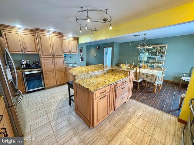 953 Capstan Dr, Forked River, NJ 08731 - kitchen with beverage cooler, stainless steel refrigerator, light stone countertops, a kitchen island, and brown cabinetry