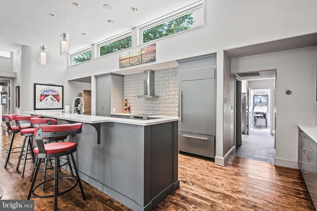 1 Regency Ct Unit 1, Baltimore, MD 21208 - kitchen with gray cabinetry, built in refrigerator, a towering ceiling, wall chimney range hood, and light countertops
