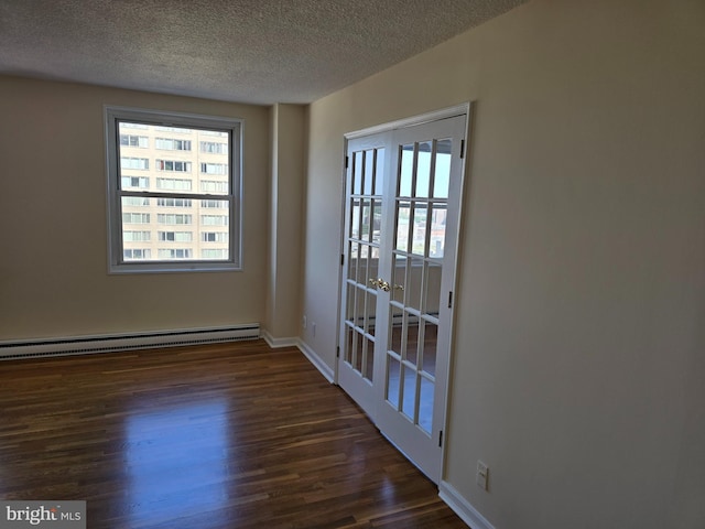 1101 Saint Paul St Unit 1212, Baltimore, MD 21202 - empty room featuring a baseboard heating unit, dark wood-style flooring, healthy amount of natural light, a textured ceiling, and french doors
