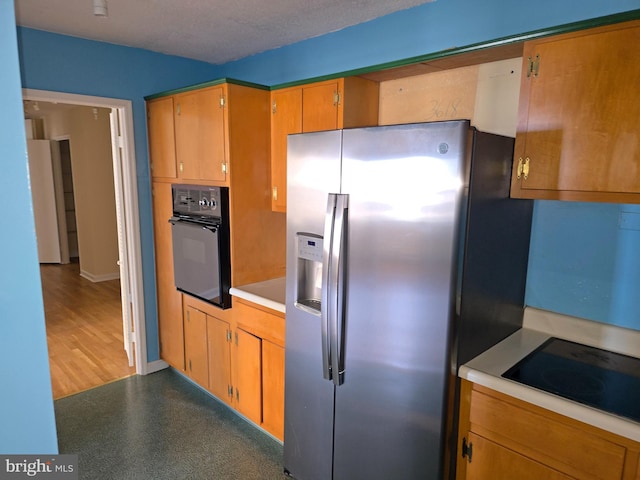 1101 Saint Paul St Unit 1212, Baltimore, MD 21202 - kitchen featuring black appliances, light countertops, and brown cabinetry