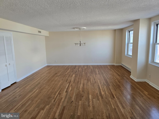 1101 Saint Paul St Unit 1212, Baltimore, MD 21202 - unfurnished dining area with baseboard heating, a chandelier, dark wood-type flooring, and a textured ceiling